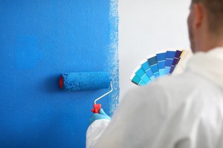 a painter painting wall in American home